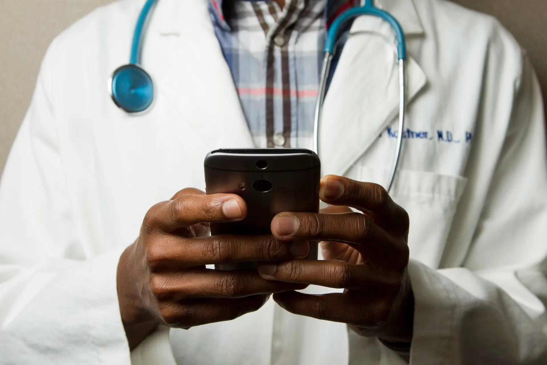 Doctor in white coat holding a smartphone